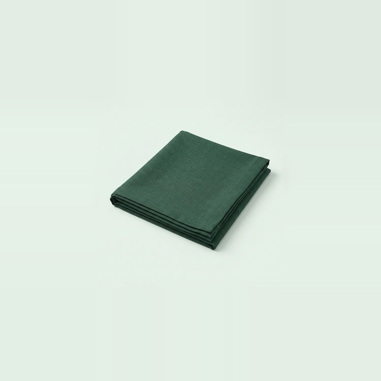 A folded dark green cloth napkin or pocket square, shown on a clean, solid, very light off-white background.