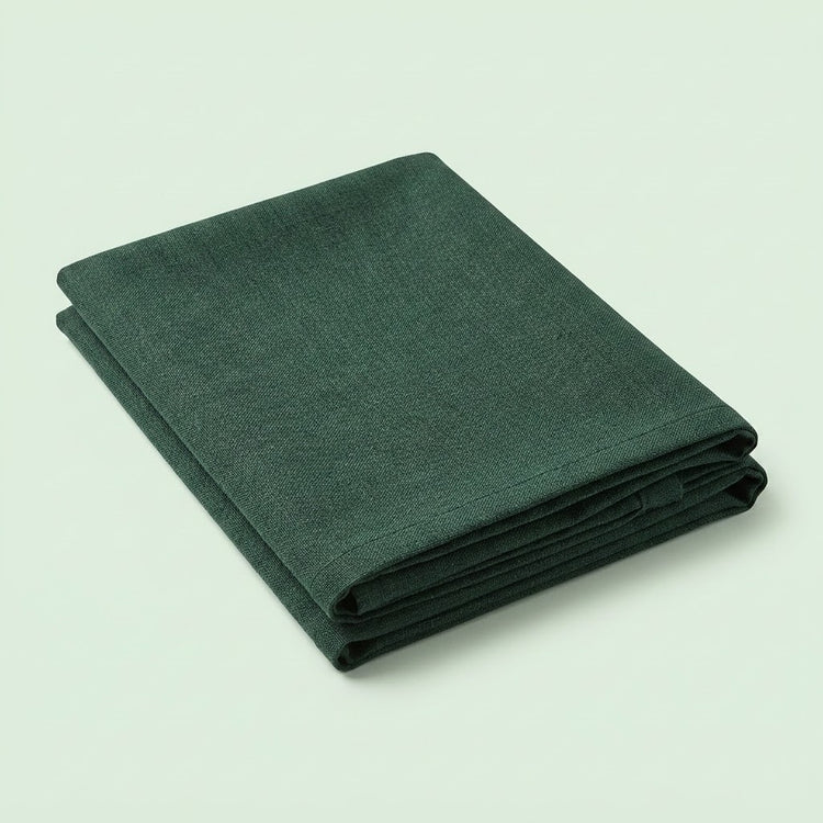A folded dark green fabric item, likely a blanket, throw, or sheet, shown on a plain light green background.