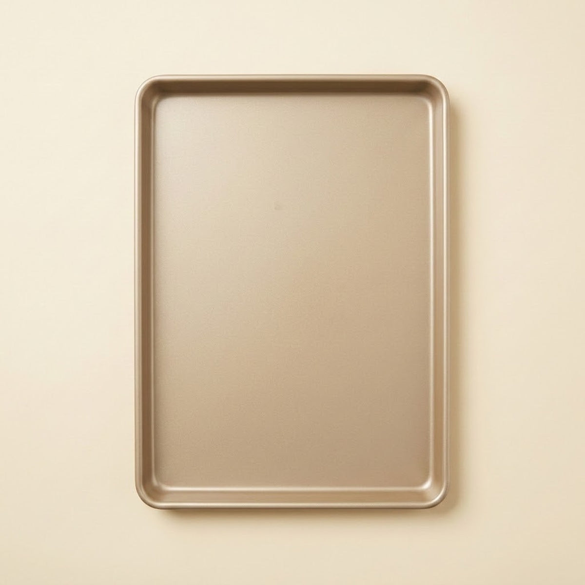 A rectangular metal baking sheet with raised rim, shown from a top-down view on a light beige background.