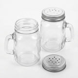 Two clear glass mason jar mugs with side handles and silver metal shaker lids, shown on a clean white background.
