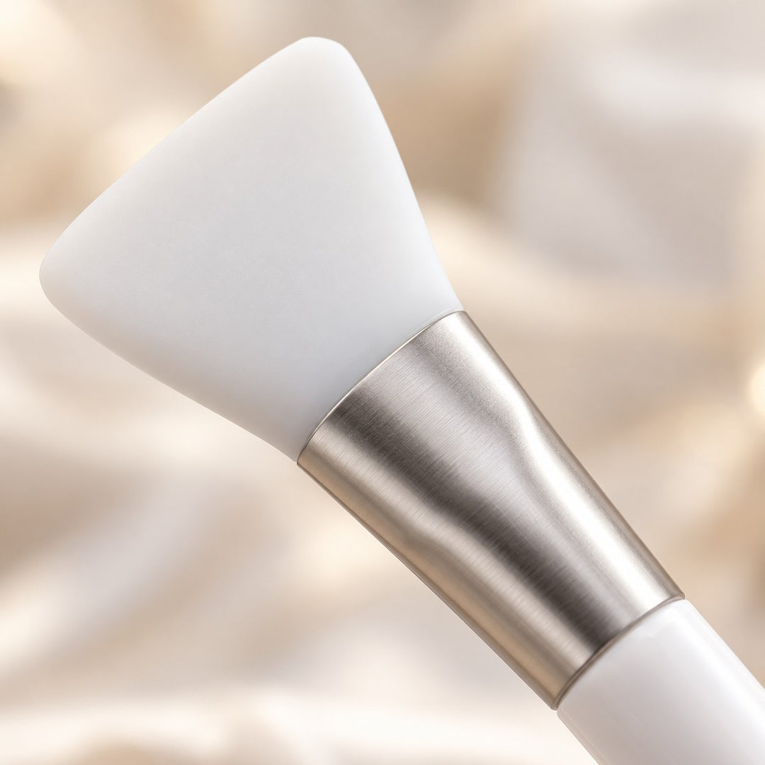 Close-up of the face mask set's smooth white silicone applicator head and silver ferrule.