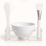 One-applicator face mask mixing bowl set with bowl, spatula, brush and clear holder on ivory.