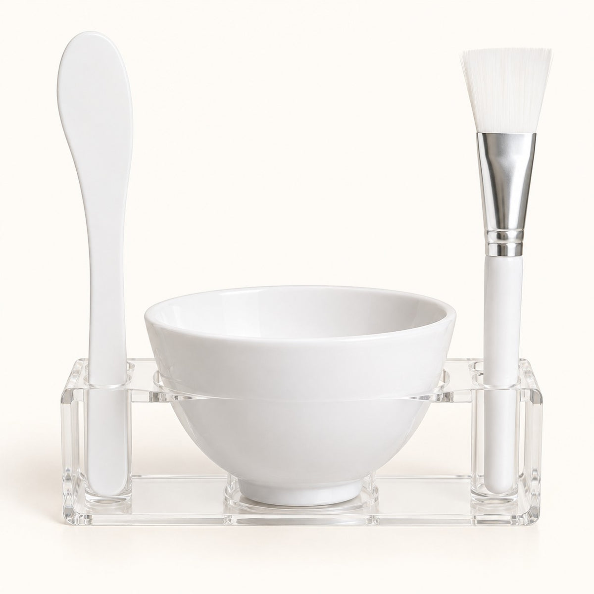 One-applicator face mask mixing bowl set with bowl, spatula, brush and clear holder on ivory.