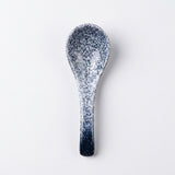 A ceramic spoon with a speckled navy blue and white glaze, shown vertically against a plain white background.