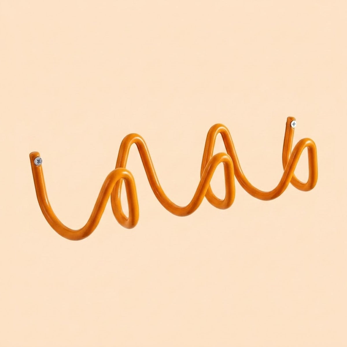 An orange wavy metal wall hook displayed against a solid pale peach background.