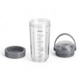 A clear plastic travel tumbler with black measurement markings, shown with a gray screw-on lid and a gray carrying handle on a white background.