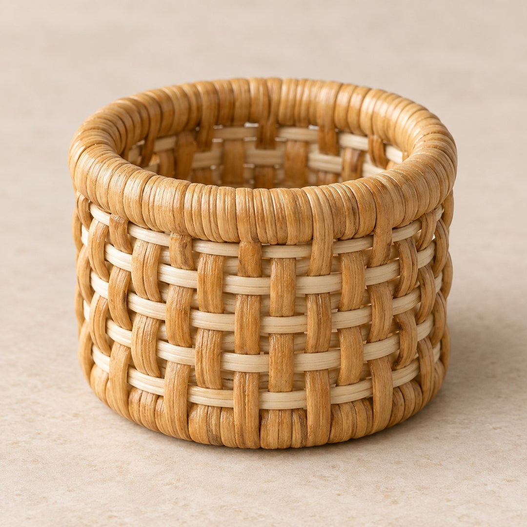 A natural tan rattan napkin ring displays its sturdy rounded rim and tight basket weave in soft light.
