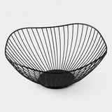 A black wire bowl with a curved, basket-like structure and a circular base, shown on a clean light gray background.