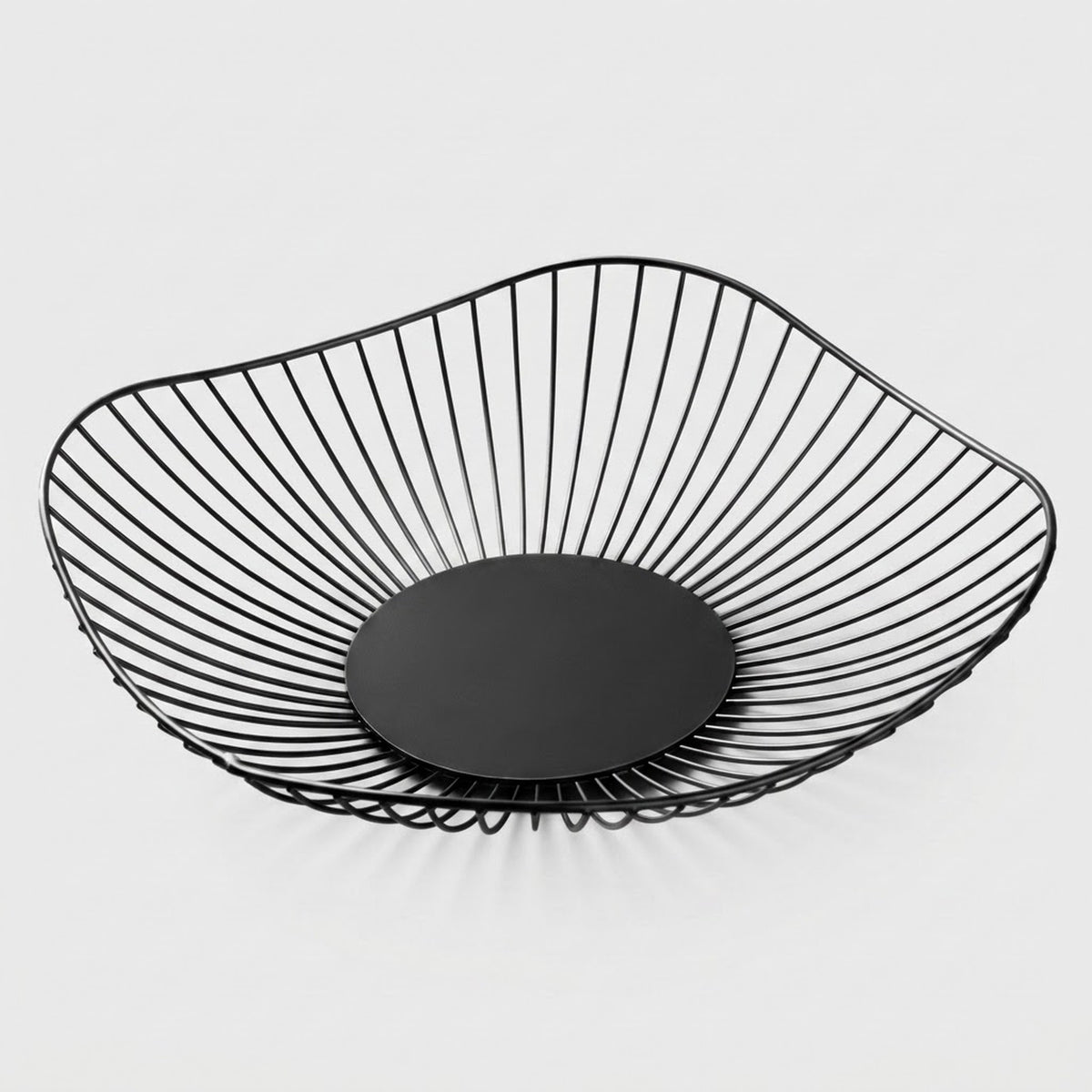 A modern black wire bowl with a slatted open design and a solid circular base, shown on a light gray background.