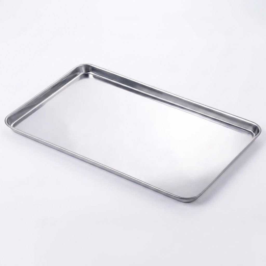 A rectangular stainless steel baking tray with raised edges, photographed on a clean white background.
