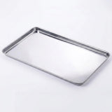 A rectangular stainless steel baking tray with raised edges, photographed on a clean white background.