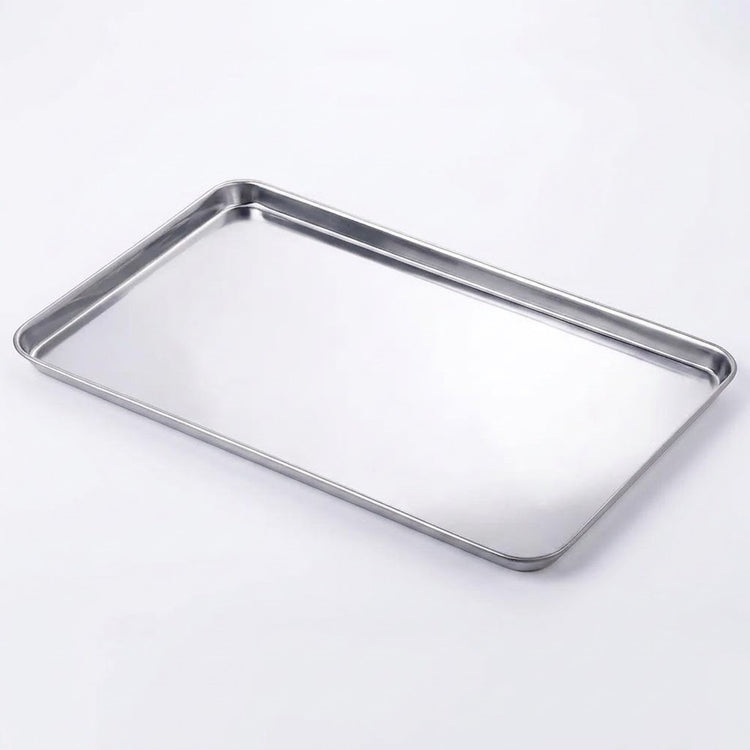 A rectangular stainless steel baking tray with raised edges, photographed on a clean white background.