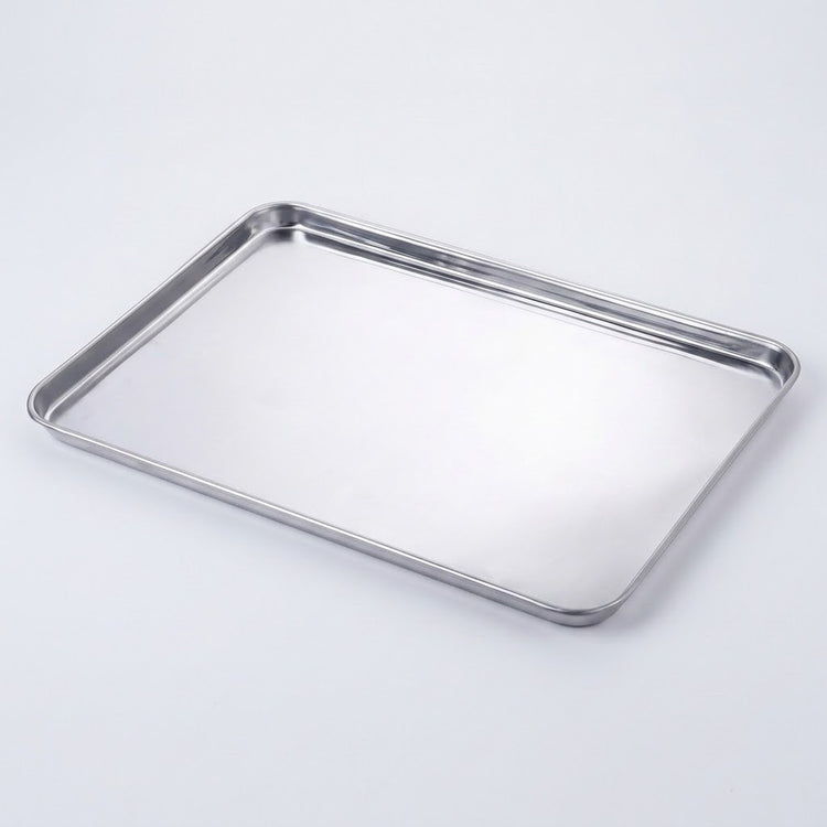 A rectangular stainless steel baking pan with raised metal rims, photographed on a clean white background.