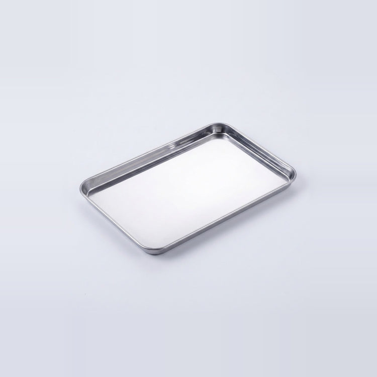 A rectangular stainless steel tray with raised edges, photographed on a clean light gray studio background.