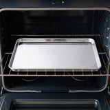 A rectangular stainless steel baking tray resting on a metal oven rack inside an open dark oven.
