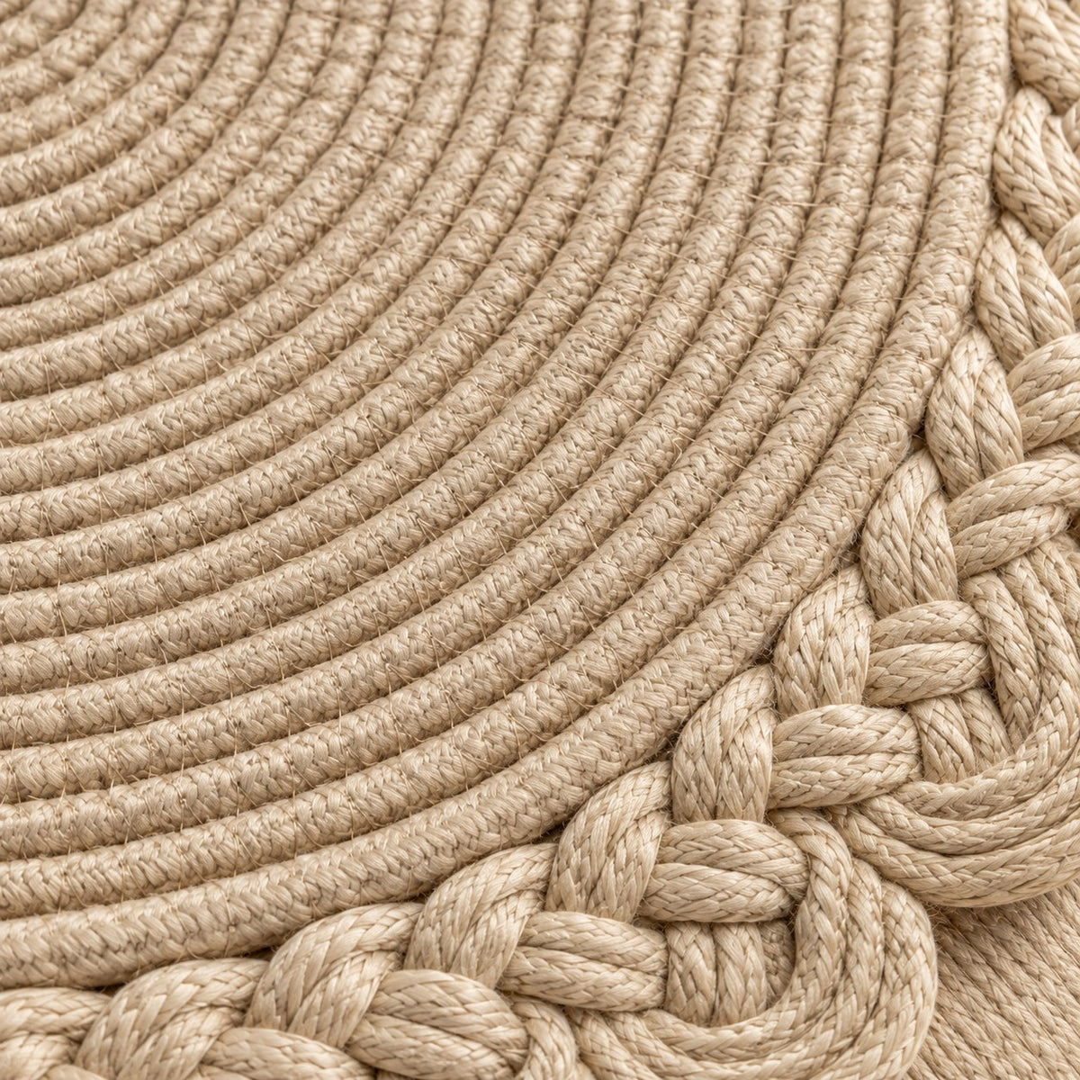 Close view of beige woven placemat cords and the braided scalloped border.