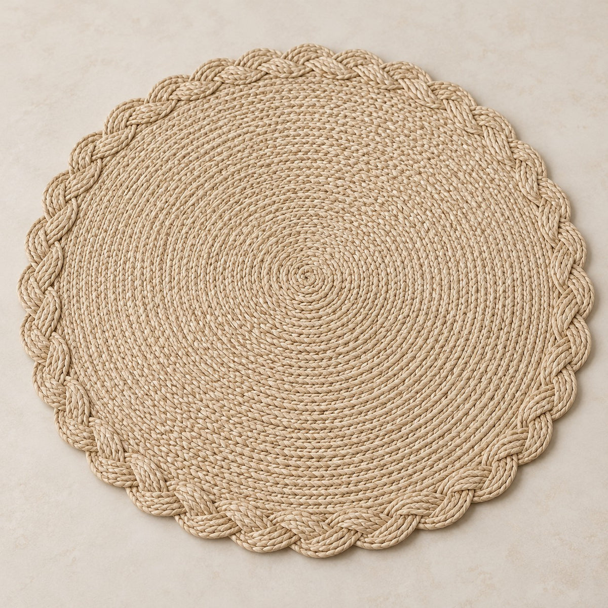 Beige round woven placemat highlights its concentric braid and scalloped braided edge.