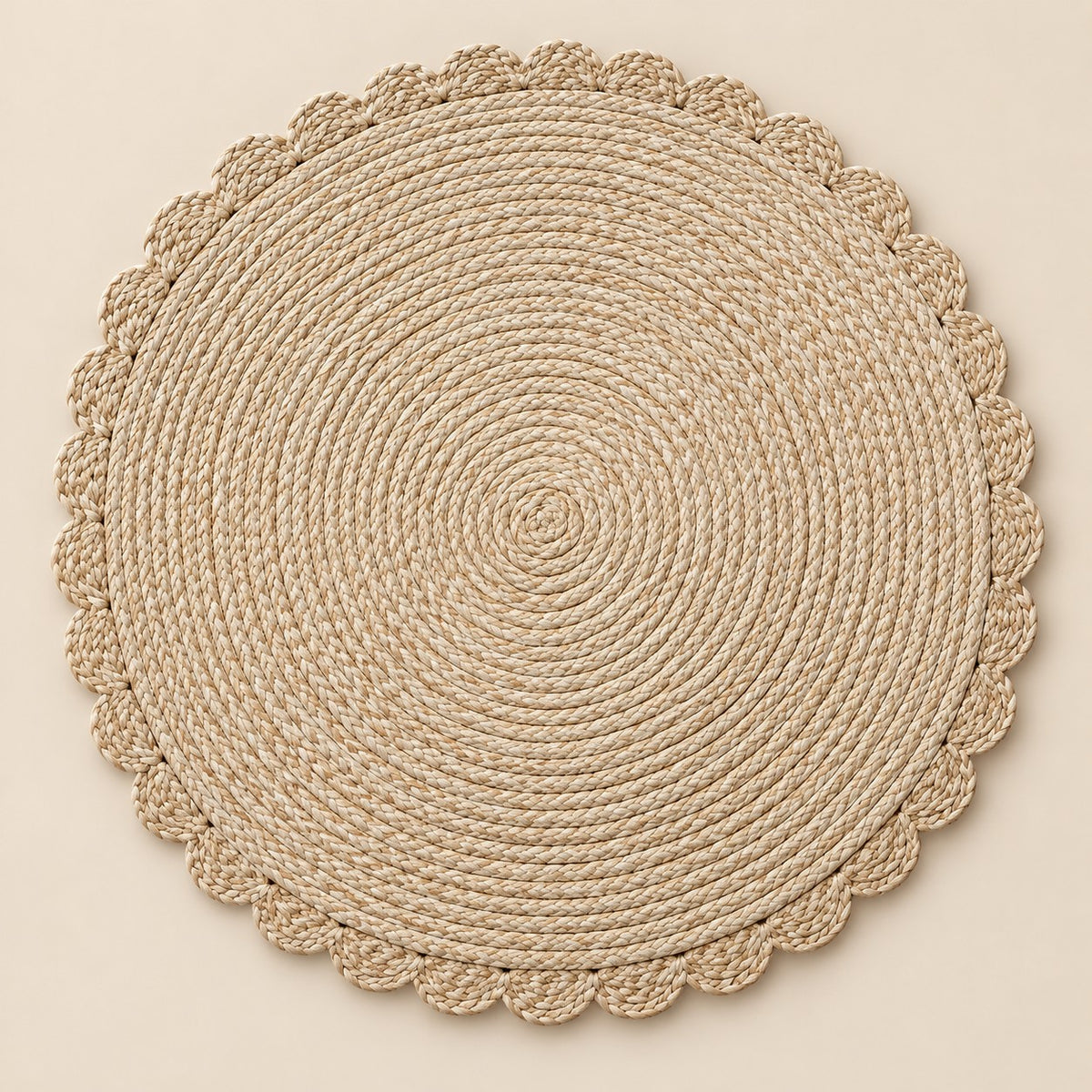Single beige round woven placemat with braided edge on a pale beige backdrop.