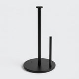 A matte black paper towel holder with two vertical stand arms and a round base, shown on a clean light gray background.