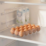 A clear plastic egg carton filled with brown eggs, shown on a refrigerator shelf with a carton in the background.