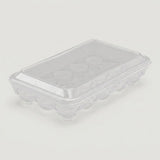 A clear plastic egg carton with a matching transparent lid, photographed on a plain light gray background.