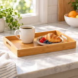 Bamboo and wood serving tray keeps a cup and plate together on a bright breakfast table.
