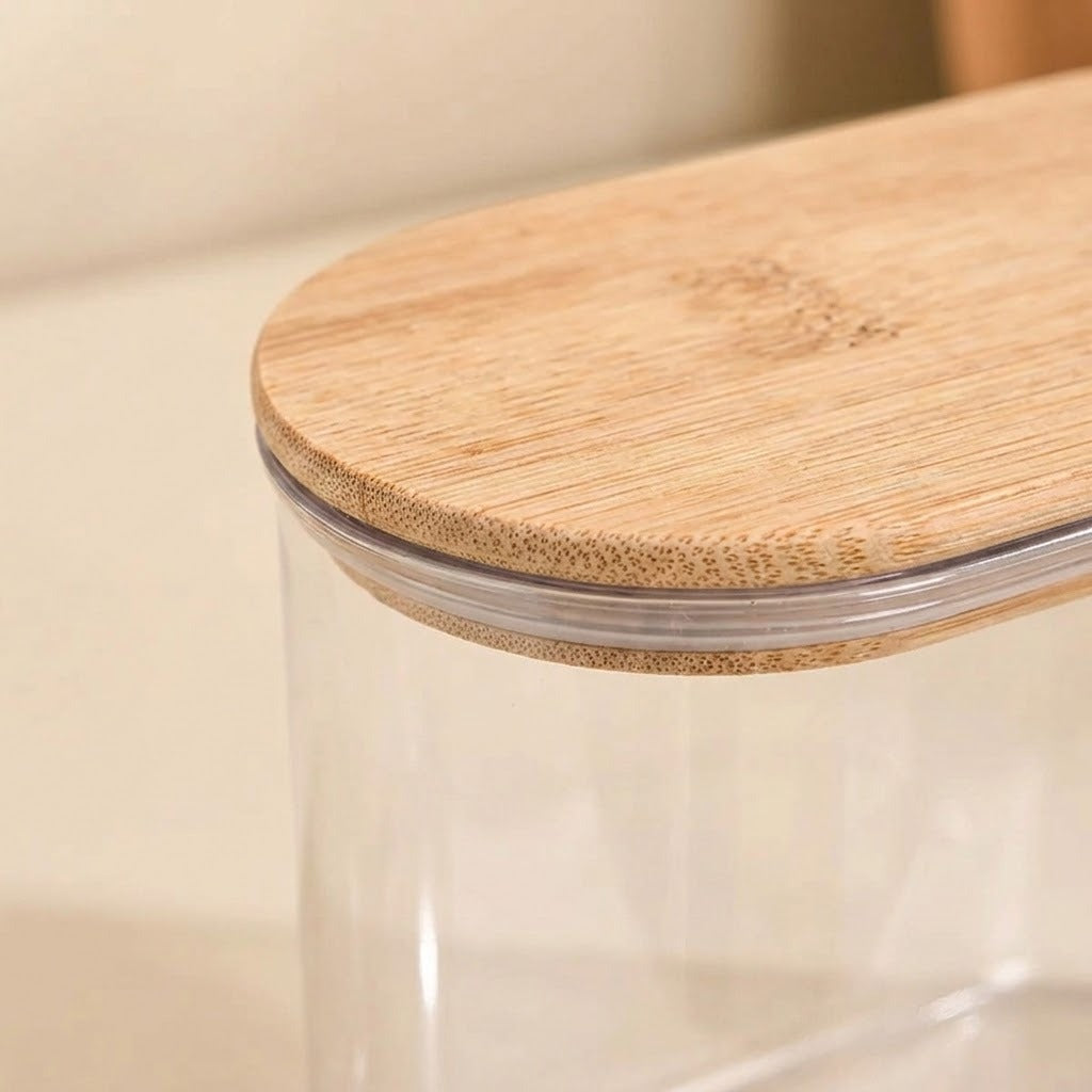 Close-up of a clear plastic storage jar with a light natural bamboo lid, showing the bamboo grain and clear plastic rim.