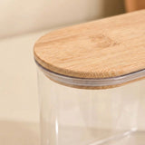 Close-up of a clear plastic storage jar with a light natural bamboo lid, showing the bamboo grain and clear plastic rim.