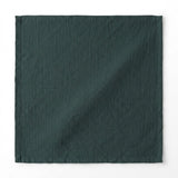 A square dark forest green fabric item, likely a napkin, pocket square, or small cloth accessory, displayed flat against a clean white background.