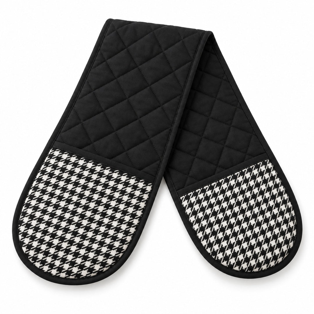 One black quilted houndstooth double oven mitt lies alone on a white background.