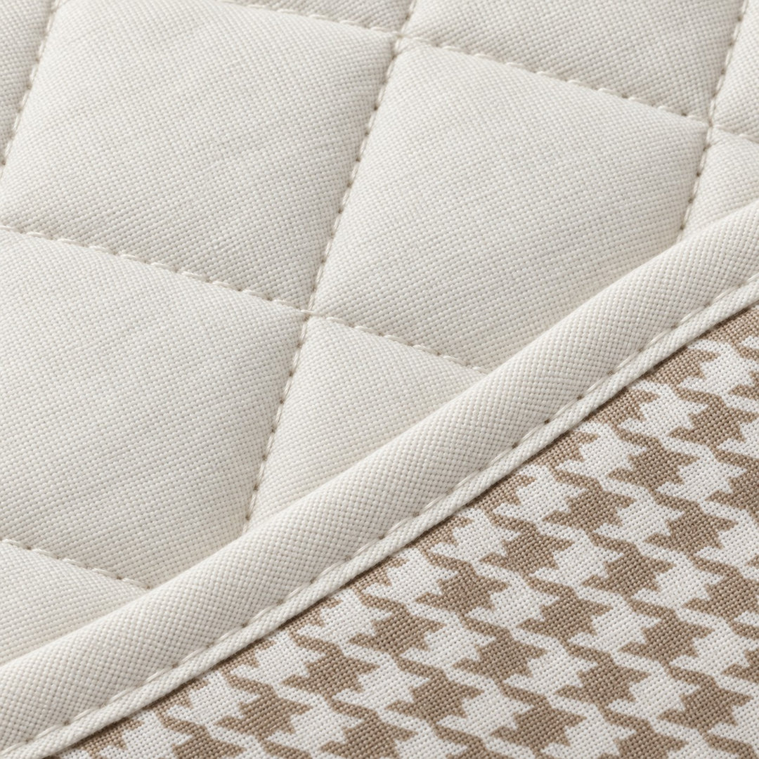 Close-up of off-white polyester quilting, stitching and houndstooth fabric texture.