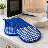 Royal blue houndstooth double oven mitt beside a bowl near an open microwave.