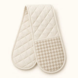 Off-white quilted houndstooth double oven mitt centered on a pale cream studio background.