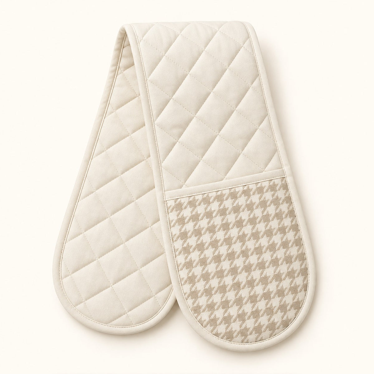 Off-white quilted houndstooth double oven mitt centered on a pale cream studio background.
