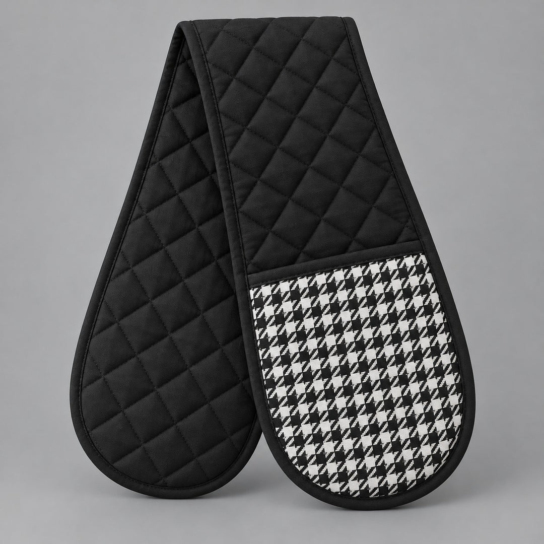 Black quilted houndstooth double oven mitt centered on a pale gray studio background.