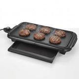 Black electric flat-top grill with six burger patties cooking on a clean white background.