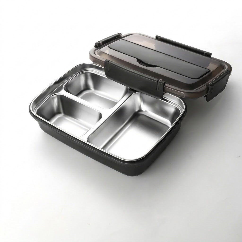 A three-compartment stainless steel lunch box with a black plastic base and a translucent dark gray lid, shown open on a white background.