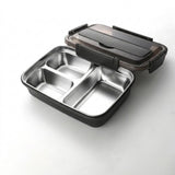 A three-compartment stainless steel lunch box with a black plastic base and a translucent dark gray lid, shown open on a white background.
