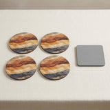 Four round coasters with a marbled wood grain pattern in brown, orange, and beige, arranged on a light beige table next to a square gray protective cover.