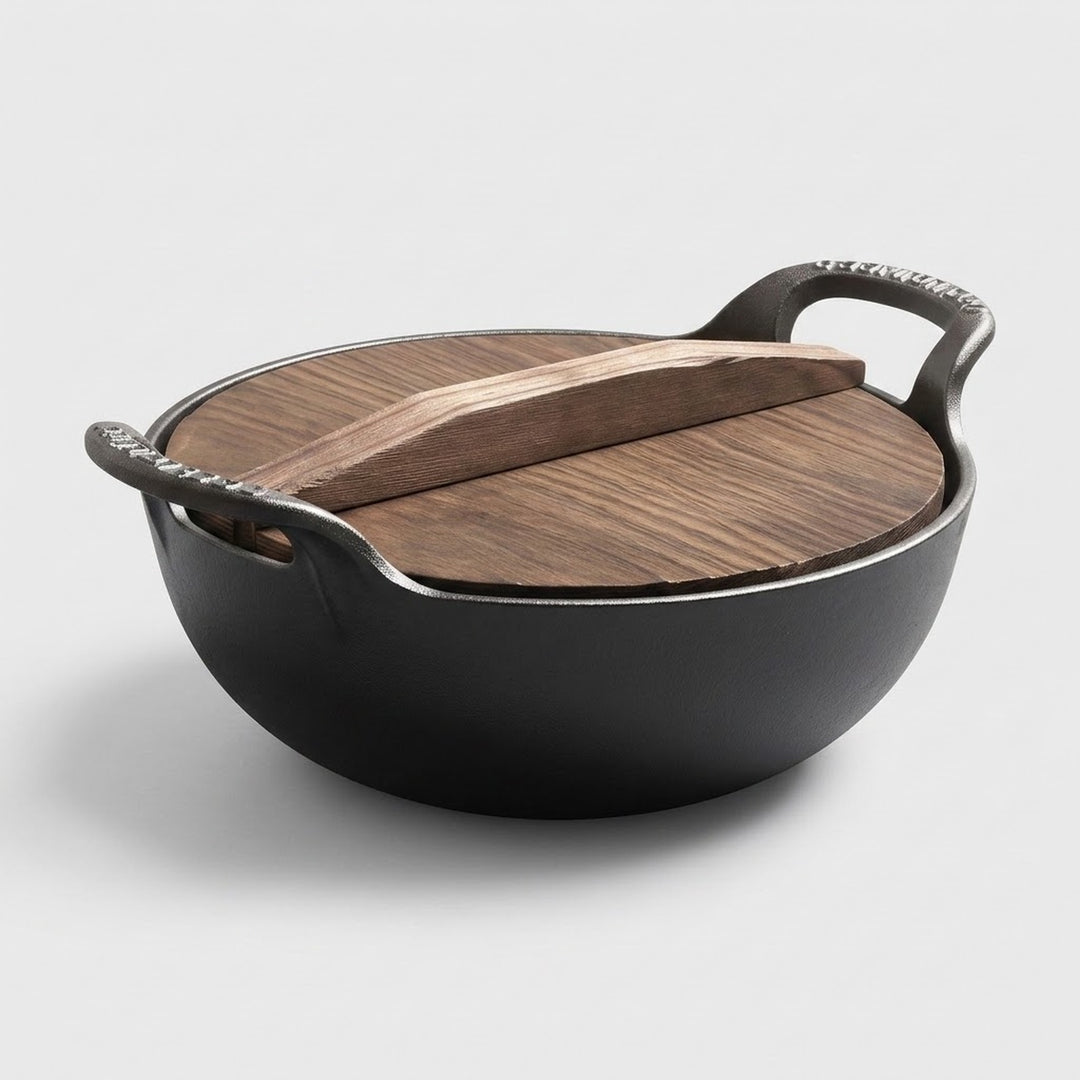 A black cast iron pot with a wooden lid and matching wooden handle, photographed on a clean light gray background.