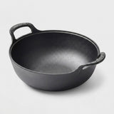 A black cast iron pot with two loop handles, photographed on a clean light gray background.