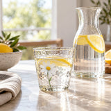 The short Hammered Daisy Glass Cup holds lemon water on a bright kitchen breakfast table.