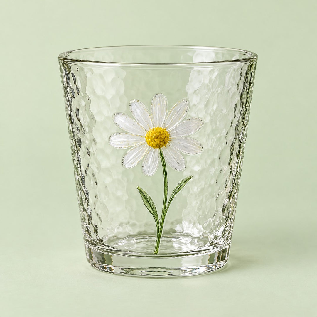 The short Hammered Daisy Glass Cup is shown alone against a pale green studio backdrop.