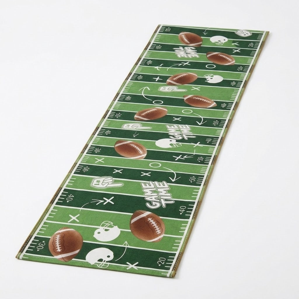 A long rectangular football-themed runner or mat with a green field pattern, white yard lines and markings, brown footballs, white helmets, and the words 'GAME TIME' on a white background.