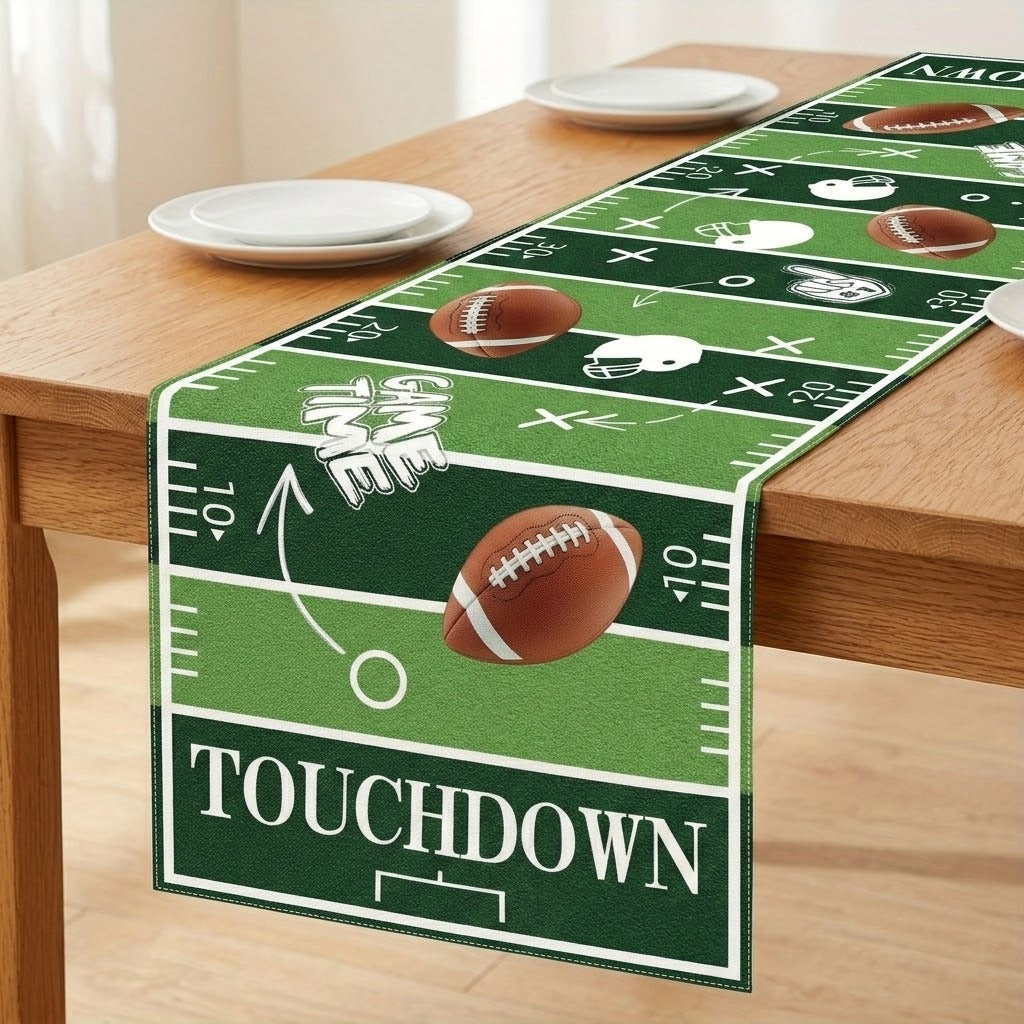 A green football field themed table runner draped over a wooden dining table, featuring white yard line markings, footballs, helmets, and the word 'TOUCHDOWN'.