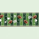 A horizontal strip of sports wall decal featuring a green football field design with white yard lines, brown footballs, white helmets, and the words 'GAME TIME' on a pale mint background.