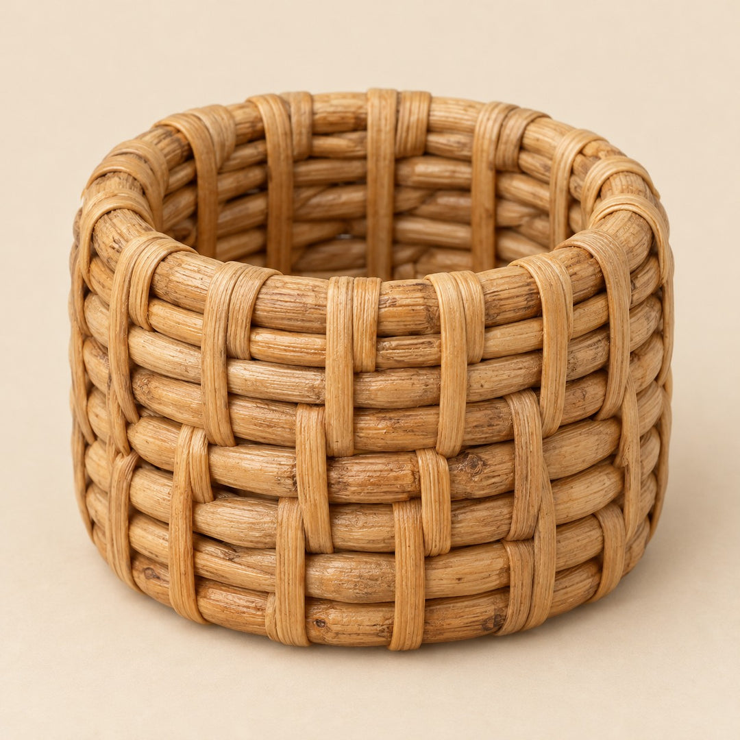 Natural basket weave rattan napkin ring shown alone on a warm straw backdrop.