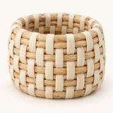 Ivory basket weave rattan napkin ring shown alone on a light ivory backdrop.