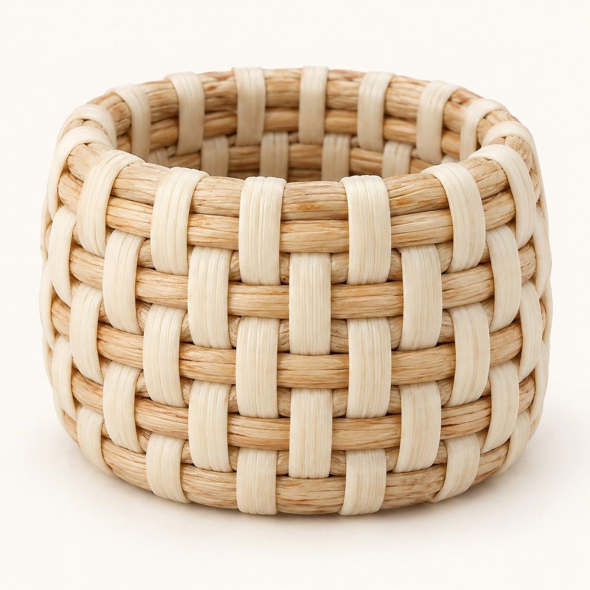 Ivory basket weave rattan napkin ring shown alone on a light ivory backdrop.