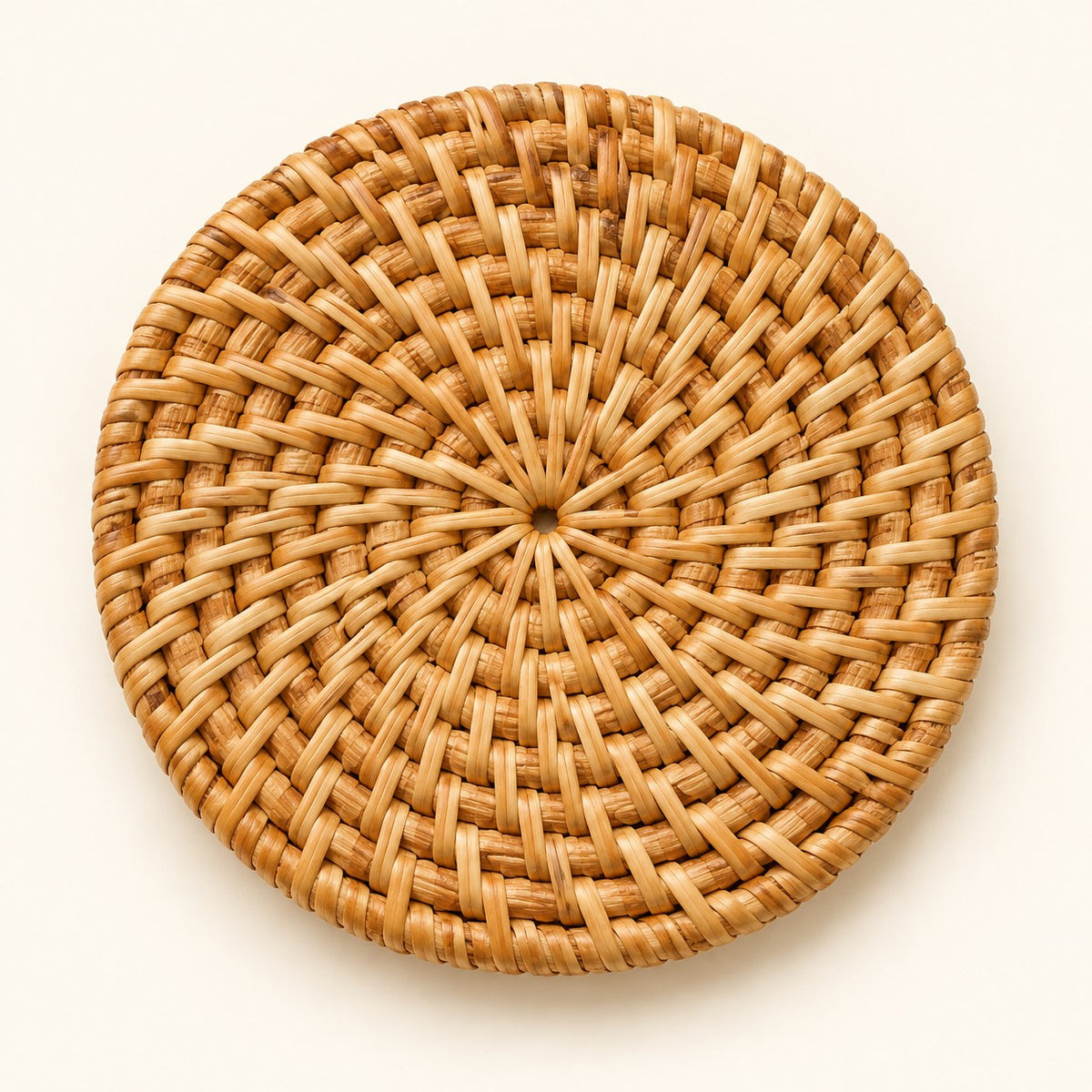 Close hero view highlights the coaster’s compact round shape and distinctive radial rattan weave.